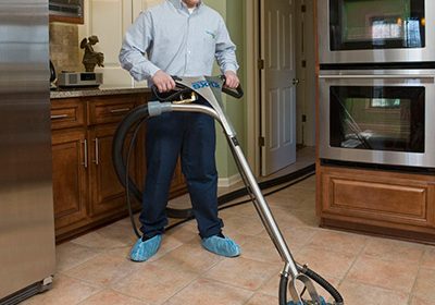 technician cleaning a kitchen floor