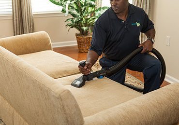 technician cleaning a sofa